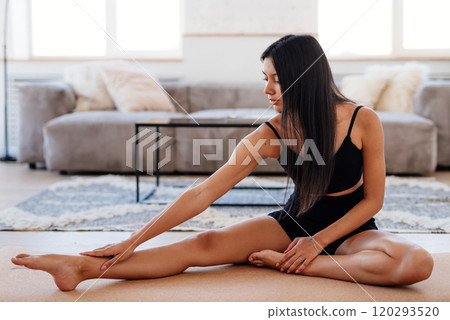 Fit woman stretching at home athletic female in sportswear doing fitness stretch exercises at home sport working out 120293520