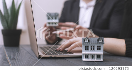Business meeting using laptop and house model: concept of real estate investment and modern technologies in work Business meeting using laptop and house model: concept of real estate investment and modern technologies in work 120293573