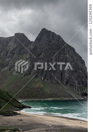 Dark clouds gather in sky behind the mountains above Kvalvika beach in Lofoten, Norway. Dark clouds gather in sky behind the mountains above Kvalvika beach in Lofoten, Norway. 120294309