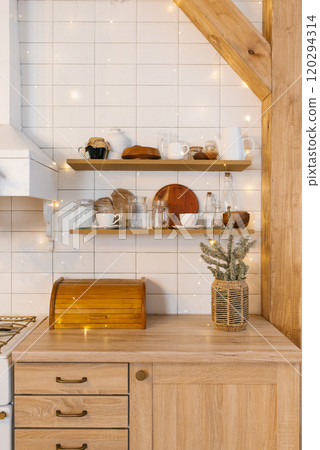 Kitchen with wooden countertops and shelves. Vase with Christmas wreaths of fir Kitchen with wooden countertops and shelves. Vase with Christmas wreaths of fir 120294314