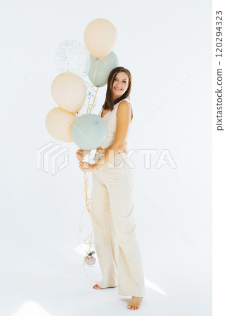 Young happy woman is holding a bunch of balloons in her hand 120294323