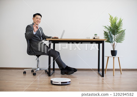 Asian businessman working with laptop in modern office setting 120294582