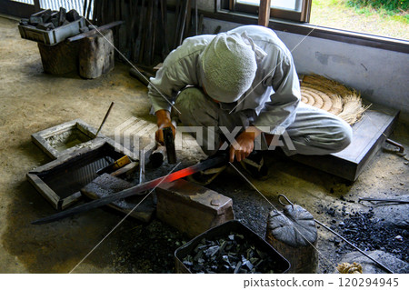 A swordsmith handcrafting a traditional Japanese sword A swordsmith handcrafting a traditional Japanese sword 120294945