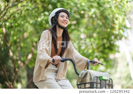 A woman is riding a bicycle to work. 120295342