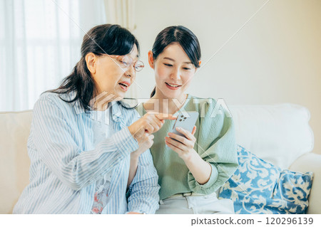 父母和孩子一邊看智慧型手機一邊進行友善的交談 父母和孩子一邊看智慧型手機一邊進行友善的交談 120296139