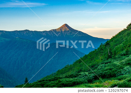Mt. Kasagatake at sunrise as seen from the tent site at Kurobe Goro hut. Climbing Mt. Soroban and Mt. Mitsumatarenge in the Northern Alps 120297074