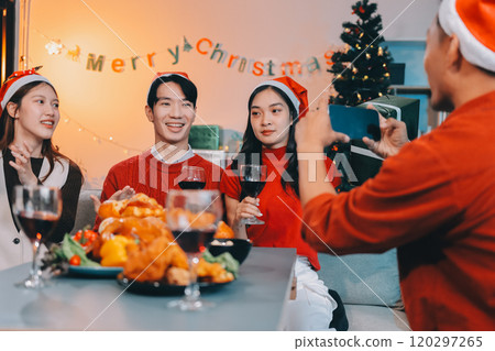 Group of young Asian man and women as friends having fun at a New Year's celebration, holding gift boxes standing by Christmas tree decoration, midnight countdown Party at home with holiday season. Group of young Asian man and women as friends having fun at a New Year's celebration, holding gift boxes standing by Christmas tree decoration, midnight countdown Party at home with holiday season. 120297265