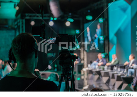 Professional video camera recording business conference panel discussion 120297583
