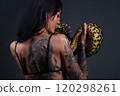 Image of the woman from back holding anaconda 120298261