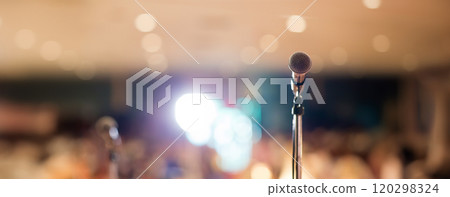 Microphone in concert hall or conference room soft and blur style for background. Microphone over the Abstract blurred photo of conference hall or seminar room background. Microphone in concert hall or conference room soft and blur style for background. Microphone over the Abstract blurred photo of conference hall or seminar room background. 120298324