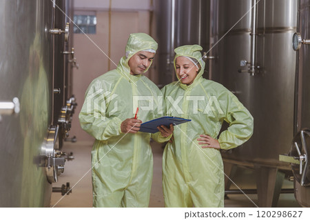 Winemaker working in modern large winery factory liquor drink industry quality. Staff inspecting wine in modern wine factory. Winery manufacturing quality control. Alcohol and wine winemaking process Winemaker working in modern large winery factory liquor drink industry quality. Staff inspecting wine in modern wine factory. Winery manufacturing quality control. Alcohol and wine winemaking process 120298627