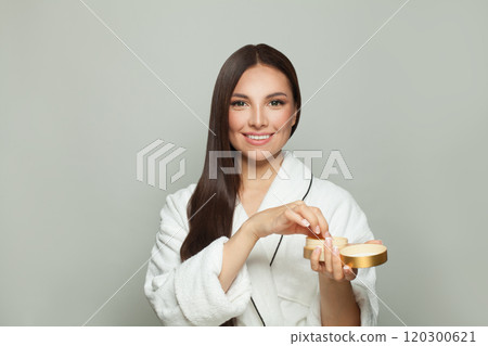 Attractive woman holding a cream tube box on white background 120300621