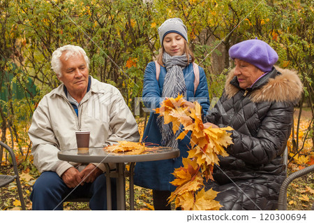 Autumn portrait of grandfather, grandmother and granddaughter outdoors Autumn portrait of grandfather, grandmother and granddaughter outdoors 120300694