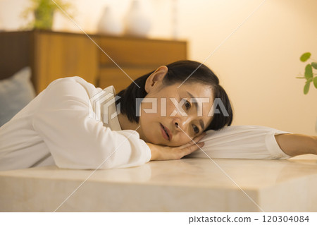 Middle-aged woman in the living room at night Middle-aged woman in the living room at night 120304084
