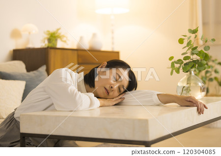 Middle-aged woman in the living room at night Middle-aged woman in the living room at night 120304085