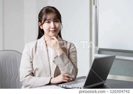 A woman resting her elbows on her desk A woman resting her elbows on her desk 120304742
