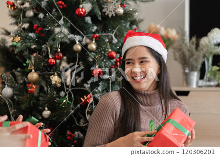 Joyful Young Couple Celebrating Christmas with Surprise Gifts in Festive Holiday Setting by Decorated Tree Joyful Young Couple Celebrating Christmas with Surprise Gifts in Festive Holiday Setting by Decorated Tree 120306201