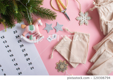 Christmas Advent calendar with gift velvet bags on a light pink background. 120306794