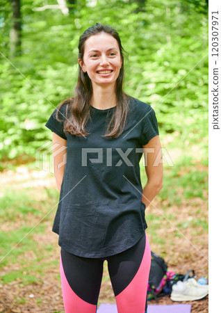 Woman practicing yoga outdoors in the forest in a serene, natural setting. Woman practicing yoga outdoors in the forest in a serene, natural setting. 120307971