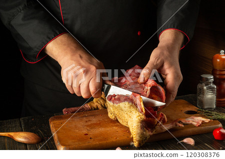 In a cozy kitchen, a chef meticulously carves a succulent roasted duck on a wooden cutting board, showcasing culinary expertise and attention to detail In a cozy kitchen, a chef meticulously carves a succulent roasted duck on a wooden cutting board, showcasing culinary expertise and attention to detail 120308376
