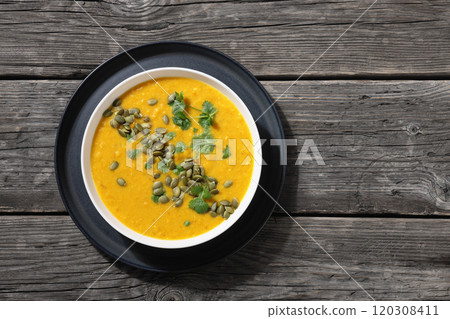 Pumpkin Red Lentil Soup in white bowl, top view 120308411
