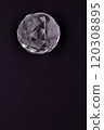 Faceted sphere, sparkling crystal on dark, black background. Large glass with light refraction, stone backdrop. Empty space for inscriptions 120308895