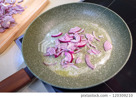Cooking red onions in a skillet over medium heat on a stovetop for a flavorful dish Cooking red onions in a skillet over medium heat on a stovetop for a flavorful dish 120309210