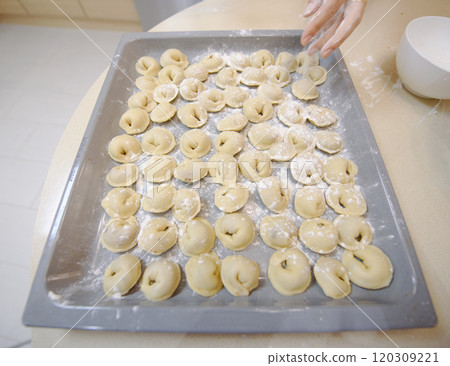 Making traditional dumplings in a cozy kitchen with flour and fresh ingredients during daytime Making traditional dumplings in a cozy kitchen with flour and fresh ingredients during daytime 120309221