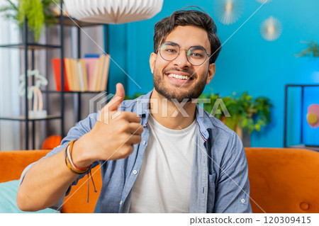Happy Indian young man looking approvingly at camera show thumbs up like positive sign good news 120309415