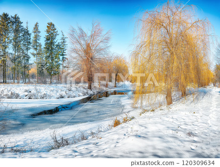 Stunning landscape with snowy trees, beautiful frozen river with reflection in water. Stunning landscape with snowy trees, beautiful frozen river with reflection in water. 120309634