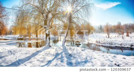 Stunning landscape with snowy trees, beautiful frozen river with reflection in water. 120309637