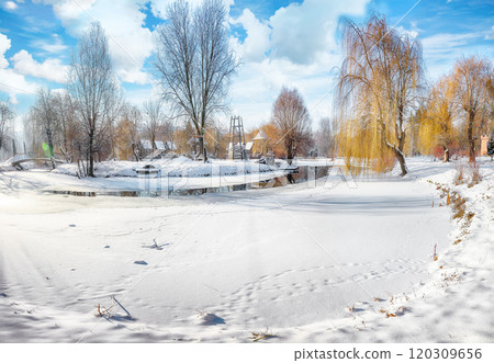Stunning landscape with snowy trees, beautiful frozen river with reflection in water. 120309656