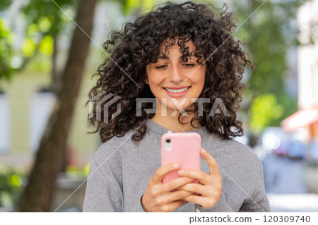 Caucasian young woman using smartphone typing text messages in social media application online Caucasian young woman using smartphone typing text messages in social media application online 120309740