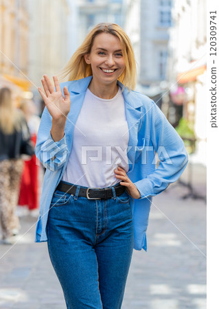 Woman tourist smiling friendly at camera waving hands gesturing invitation hello hi greeting goodbye 120309741