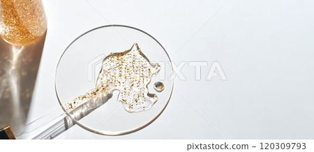 Luxurious gold-infused serum in dropper and circle on minimalist white Luxurious gold-infused serum in dropper and circle on minimalist white 120309793