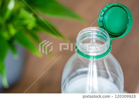 Stationary plastic cap on a PET bottle. The new design means the cap remains attached to the bottle after opening, making the entire package easier to collect and recycle 120309928