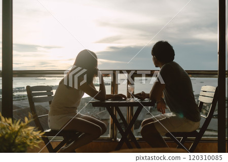 Lover couple having dinner enjoy date at private terrace with evening ocean. Lover couple having dinner enjoy date at private terrace with evening ocean. 120310085