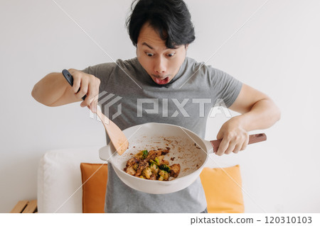 Happy man proud and present his homemade meal in the pan. Happy man proud and present his homemade meal in the pan. 120310103