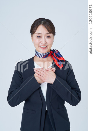 A woman in a suit with her hands on her chest 120310671