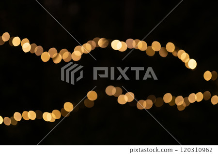 Decorative string lights at night time, Defocused Background, night city backdrop, party time with Yellow bokeh balls. Abstract blurred warm light 120310962