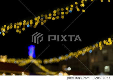 Decorative string lights at night time, Defocused Background, night city backdrop, party time with Yellow bokeh balls. Abstract blurred warm light 120310963