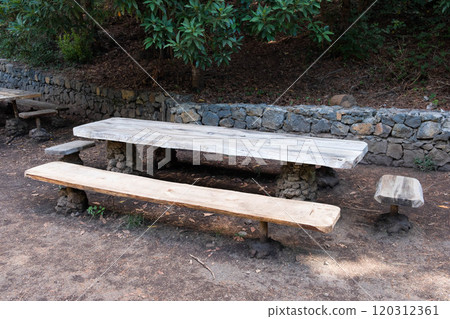 wooden table and bench in forest. Picnic spot on hiking trail wooden table and bench in forest. Picnic spot on hiking trail 120312361