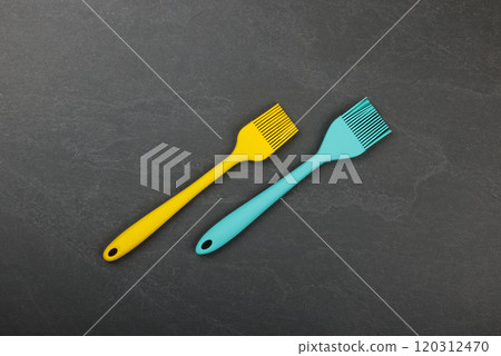 Two silicone culinary brushes on black slate board Two silicone culinary brushes on black slate board 120312470