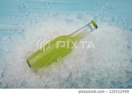 One glass bottle of green drink on crushed ice 120312499