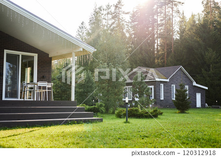 At angle image of green suburban area with two brick houses with trees in background copy space 120312918