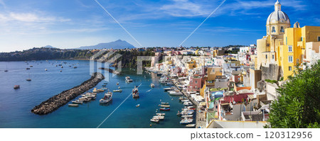 Italy travel and landmarks. Most scenic and colorful island - beautiful Procida in gulf of Naples. Port of Corricella panoramic view with yellow church Italy travel and landmarks. Most scenic and colorful island - beautiful Procida in gulf of Naples. Port of Corricella panoramic view with yellow church 120312956