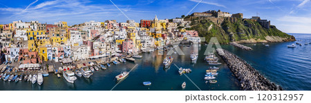 Italy travel and landmarks. Most scenic and colorful island - beautiful Procida in gulf of Naples. Port of Corricella panoramic view with yellow church Italy travel and landmarks. Most scenic and colorful island - beautiful Procida in gulf of Naples. Port of Corricella panoramic view with yellow church 120312957