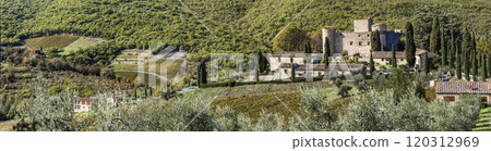 Italy, Tuscany landscape with cypresses. Scenic medieval castle and hotel surrounded by vineyards in autumn colors - Castello di Meleto in Chianti region. Italy, Tuscany landscape with cypresses. Scenic medieval castle and hotel surrounded by vineyards in autumn colors - Castello di Meleto in Chianti region. 120312969