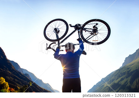 male cyclist with a raised bicycle against the backdrop of the sun and mountains male cyclist with a raised bicycle against the backdrop of the sun and mountains 120313321