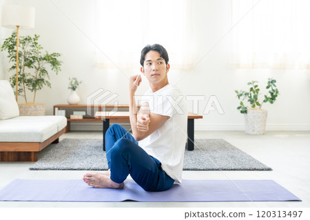 Young man doing yoga at home Young man doing yoga at home 120313497